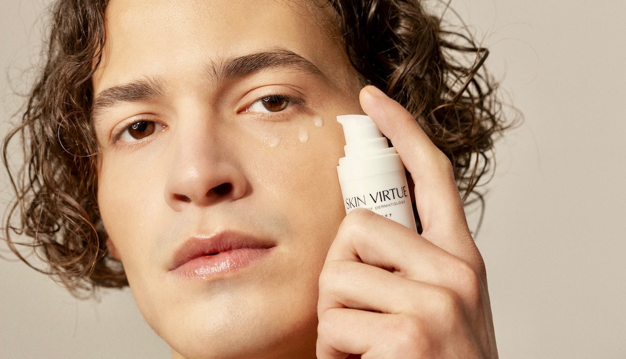 Male model holding an Future Advanced Eye Cream | Skin Virtue