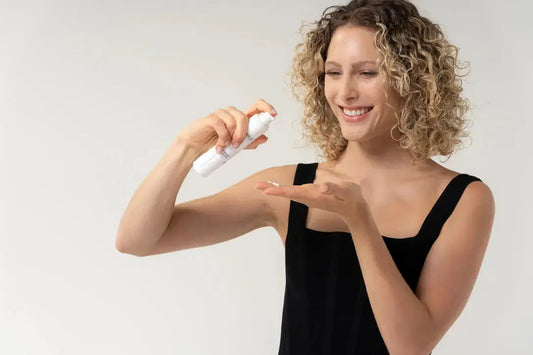 White 28 year old model hold Skin Virtue Pure Nourish Moisturising Creamcream pouring it into hand looking the the texture and smiling