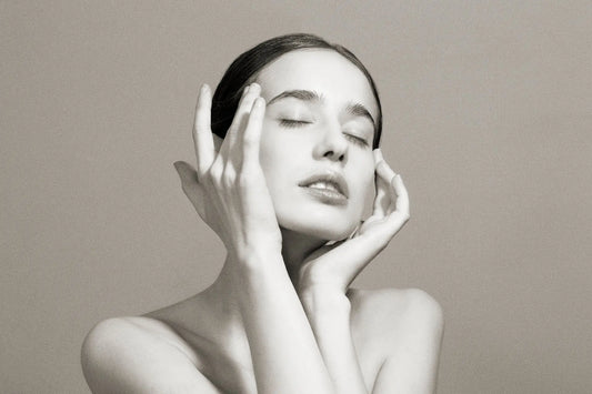28 year old white model holding her face with black and white backdrop