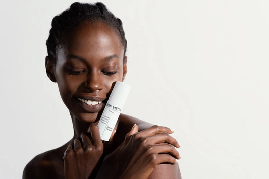 35_year_old_black_model_smiling_holding_the_Skin_Virtue_Future_Advanced_Radiance_Serum