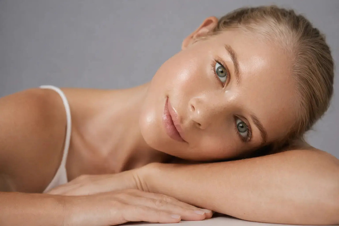 young model laying flat on her arms looking into the camera