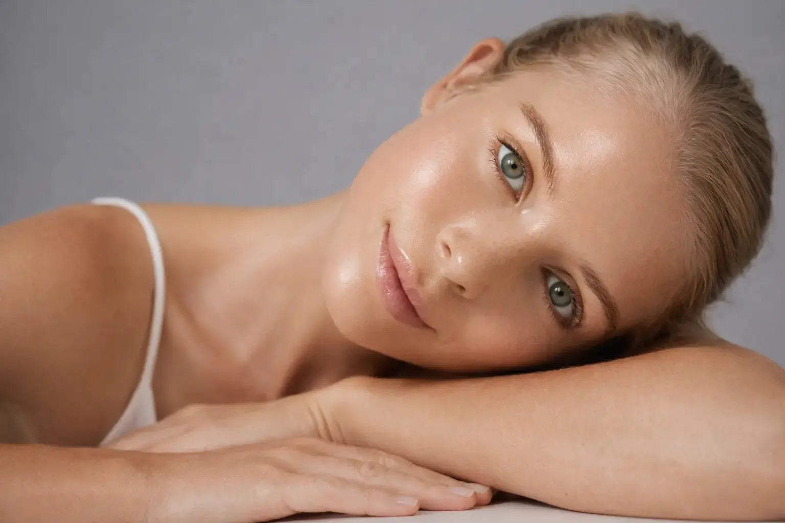 young model laying flat on her arms looking into the camera