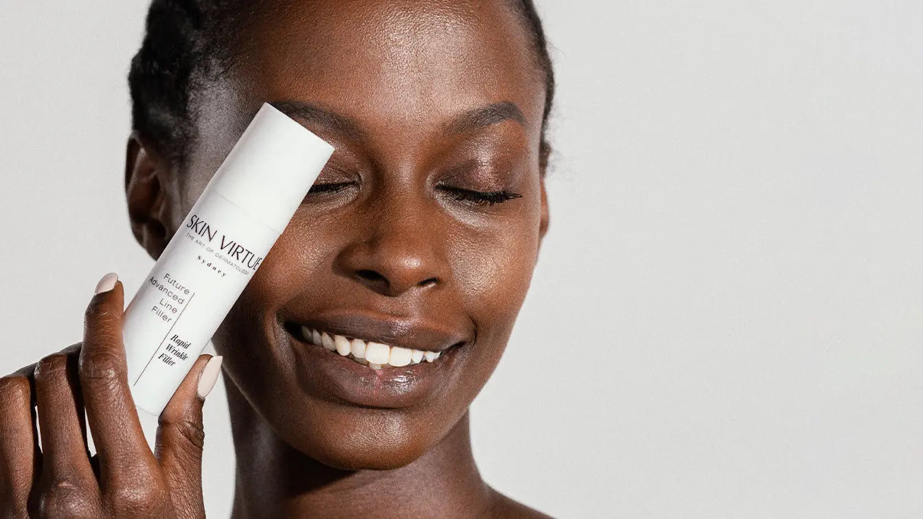 Woman holding a skincare product with a plain background