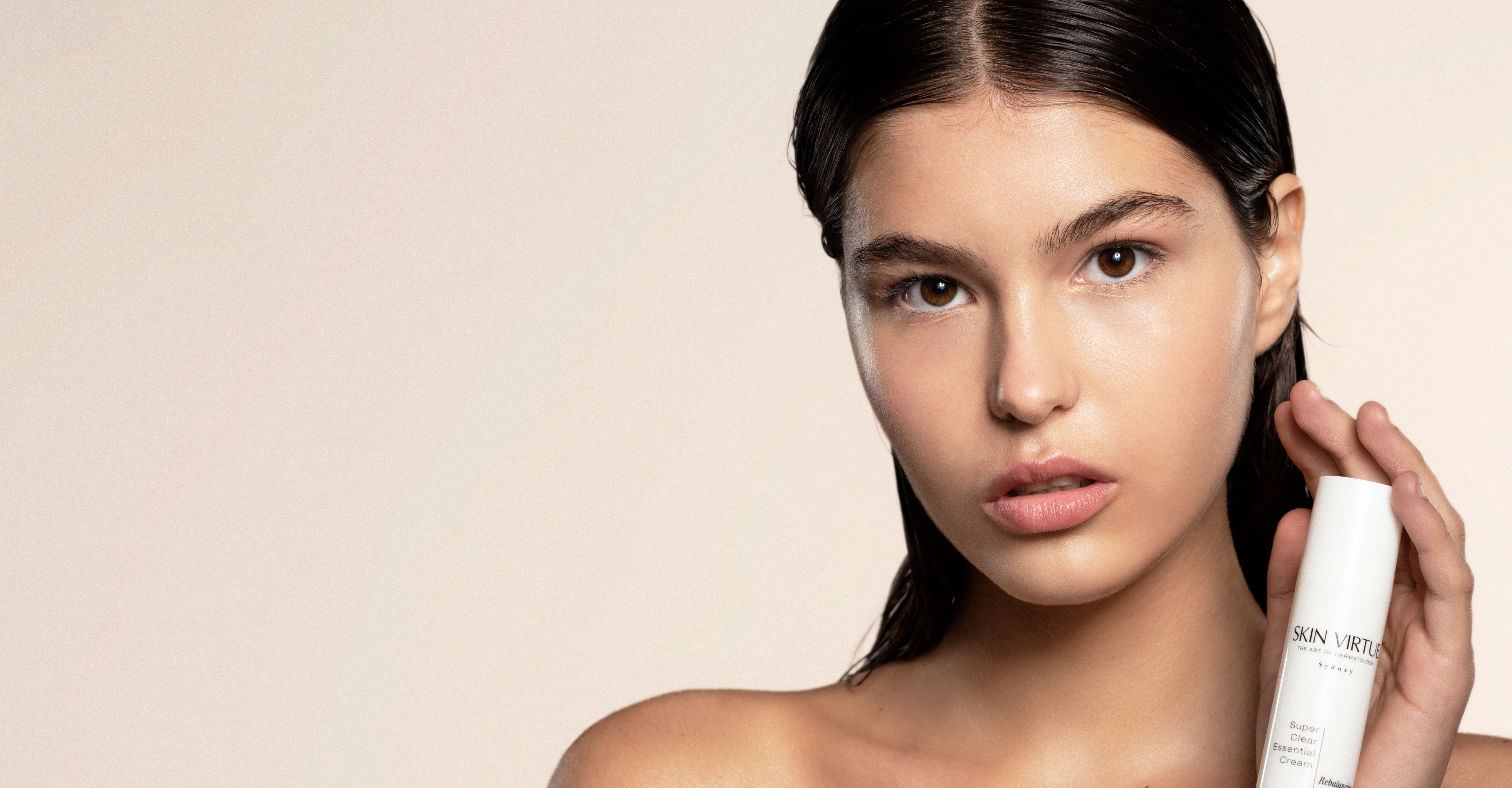 Skin Virtue 23 year old white model holding Super Clear Essential Cream 